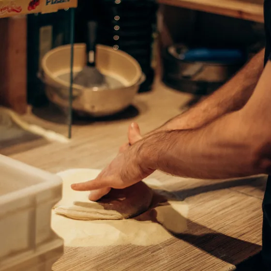 Hands kneading fresh pizza dough